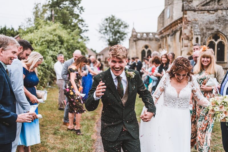 A documentary wedding photographer captures a candid confetti moment with the bride and groom in Berkshire.