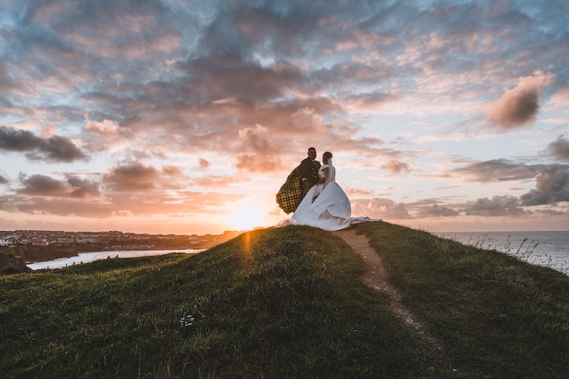 A raw documentary wedding photograph on the Cornwall coastline capturing the cinematic scale and unscripted energy of the shore.