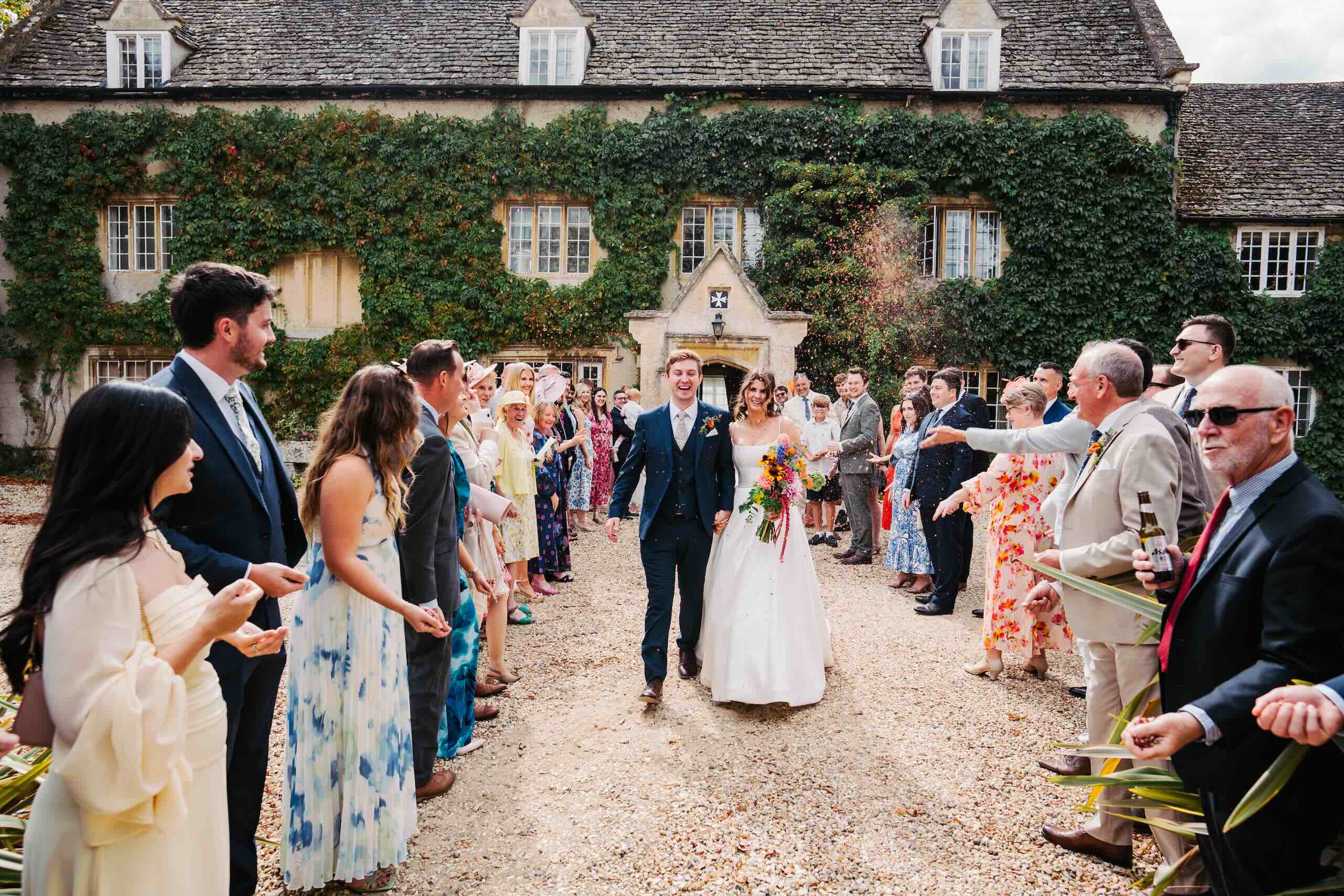 Bride and groom walking through confetti at Friars Court in Clanfield