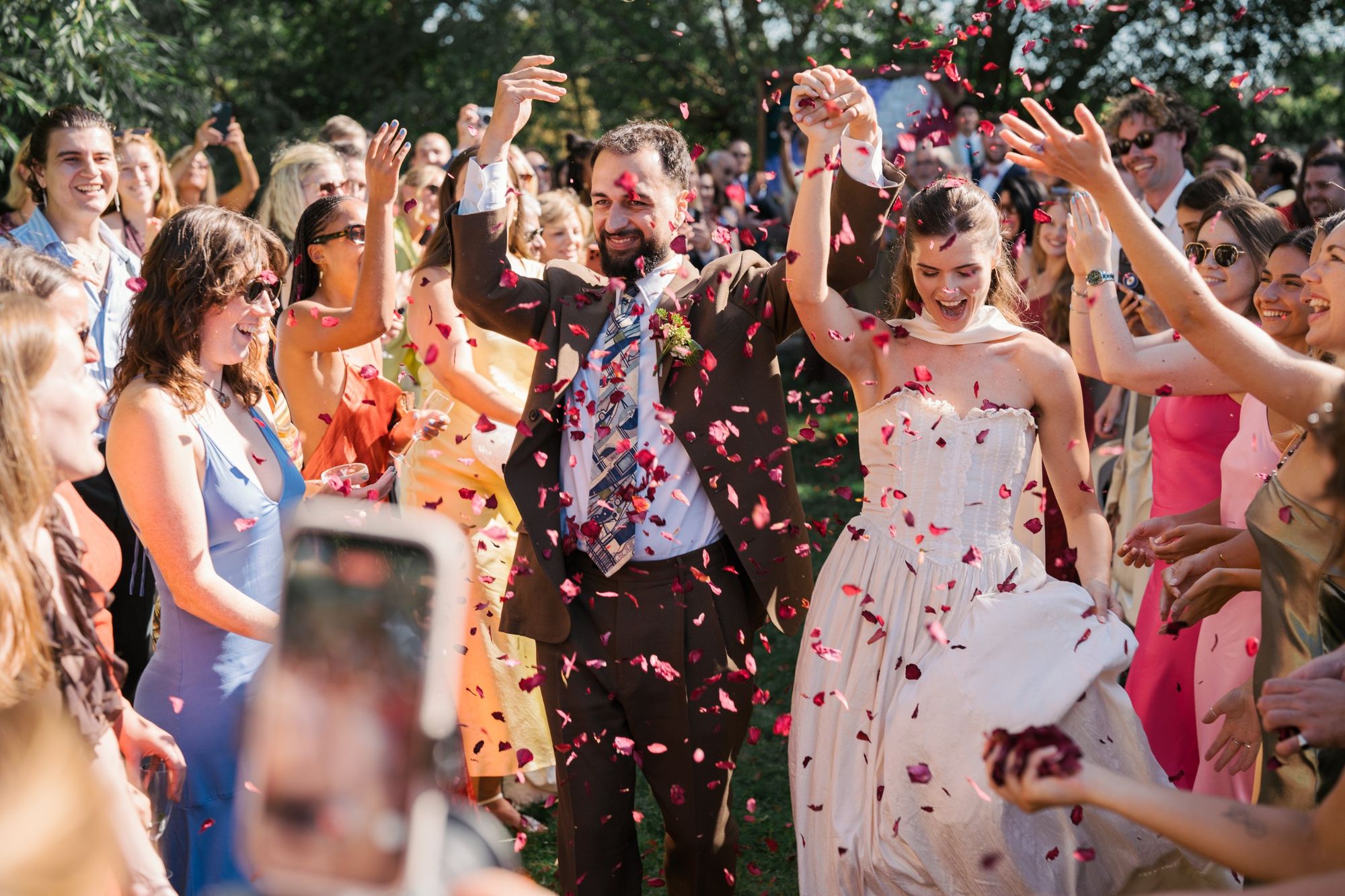 Couple walking through rose petals at Isis Farmhouse, Oxford
