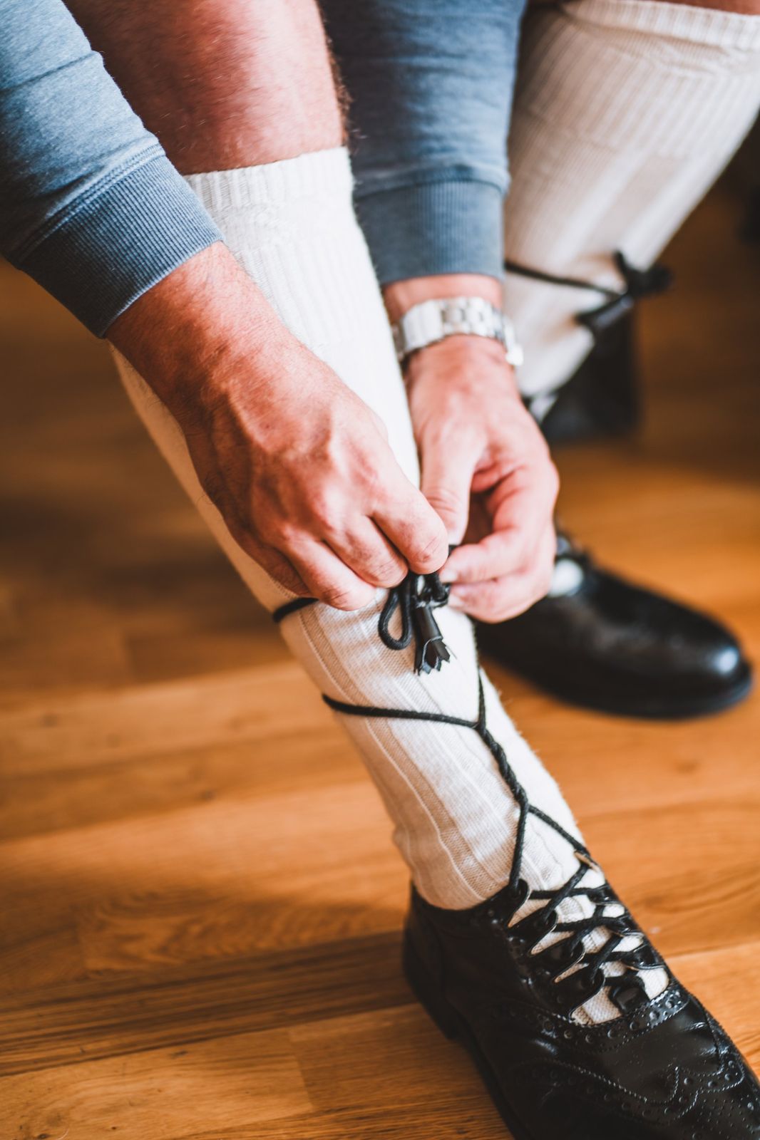 Groom tying his kilt hose before a Newquay wedding