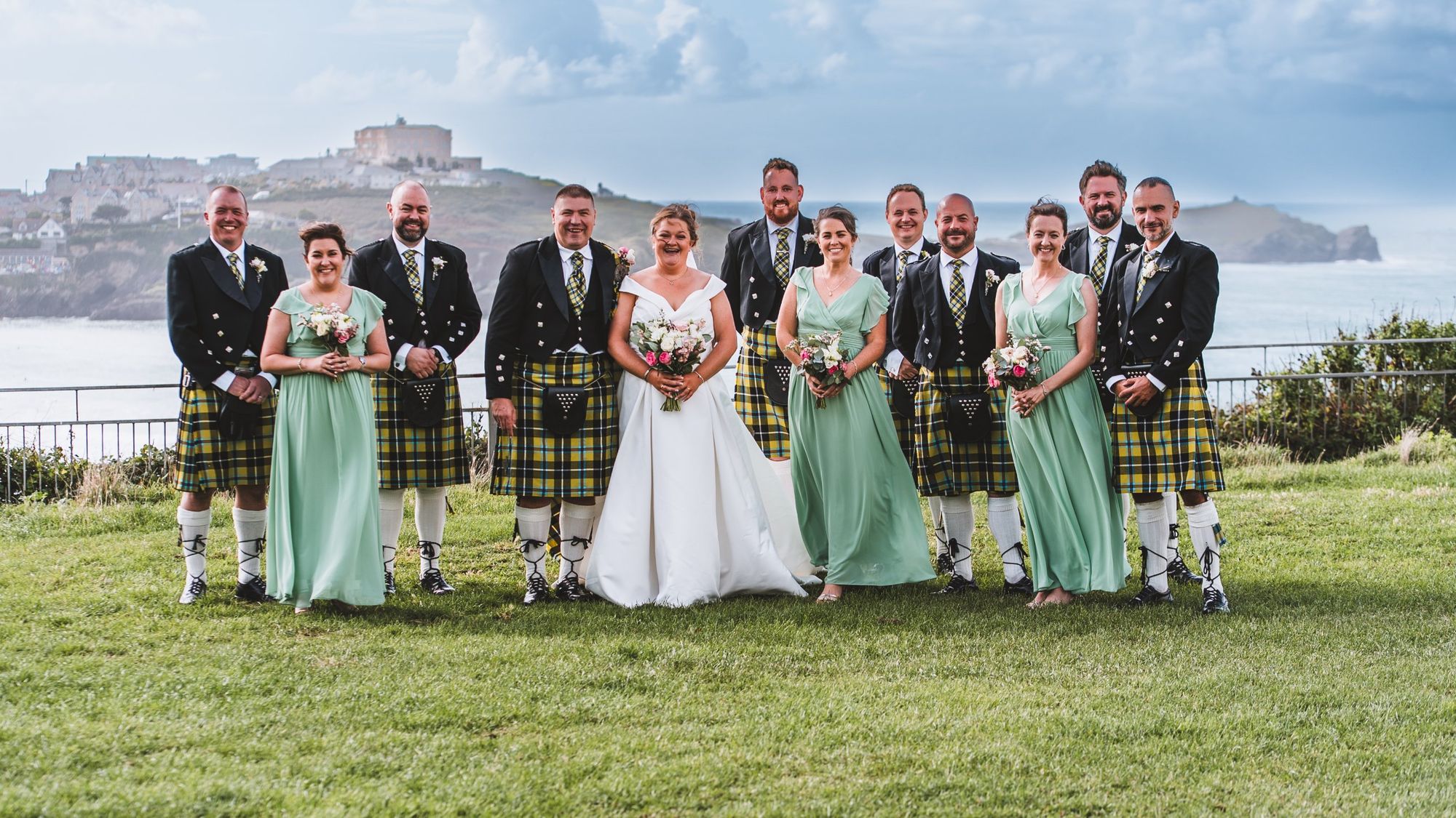 Wedding party in kilts with the Newquay headland behind