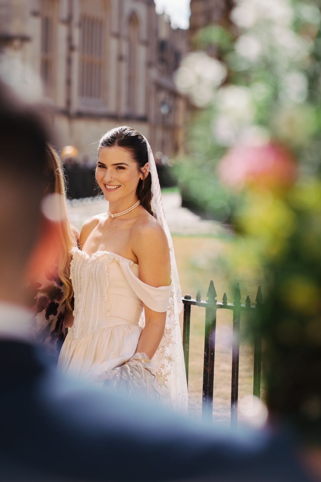 Bride smiling by college railings in Oxford