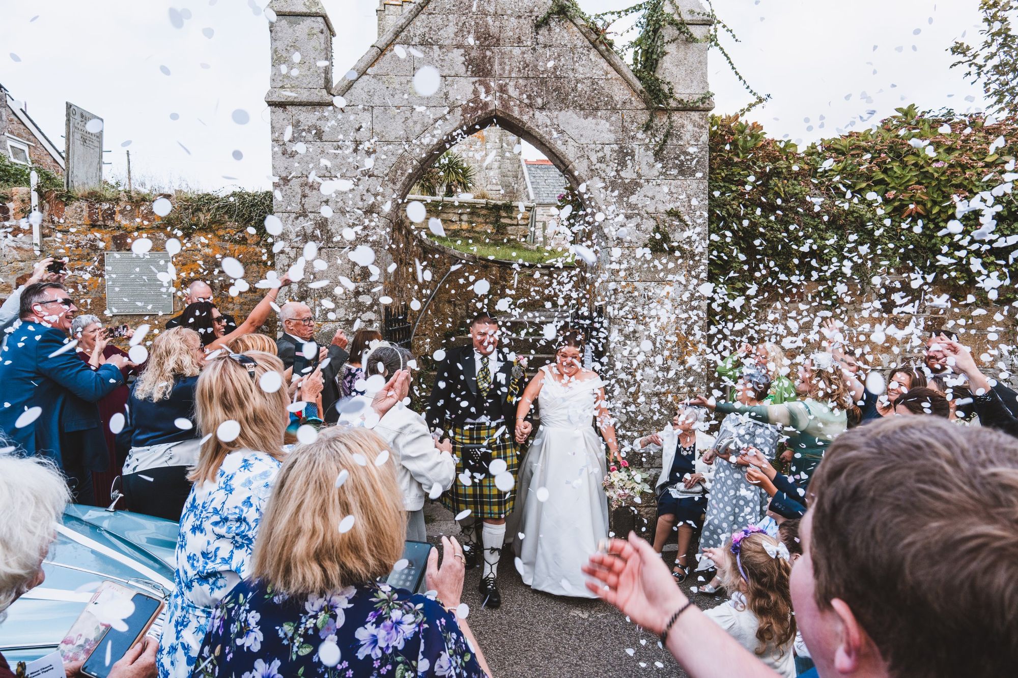 Confetti exit by the stone archway at St Columb Minor church