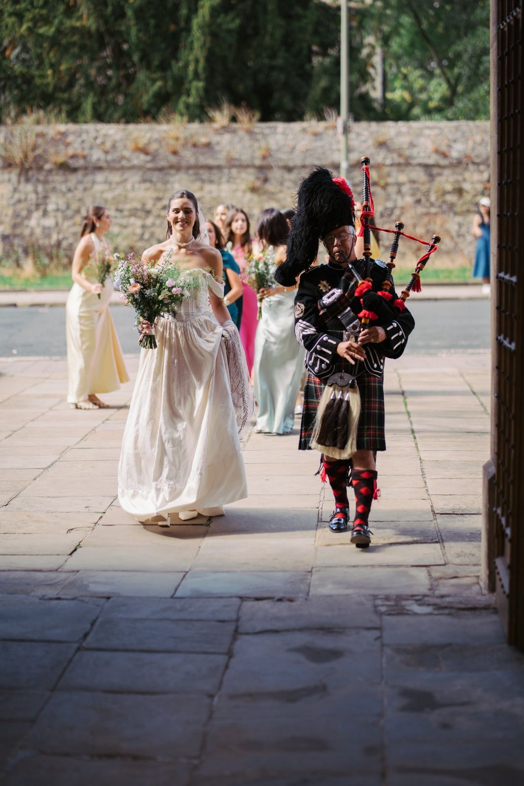 Bride arriving at Wadham College led by a bagpiper