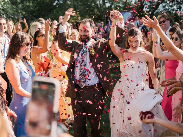 Couple walking through rose petals at Isis Farmhouse, Oxford