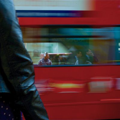 A documentary London wedding photograph featuring a classic red bus and the high-contrast urban energy of the city.