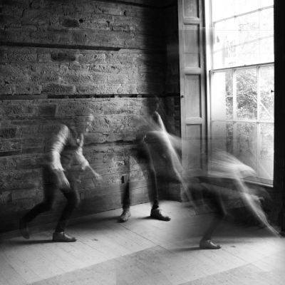 A high-contrast documentary wedding photograph on 35mm black and white film, showing authentic grain and cinematic light.